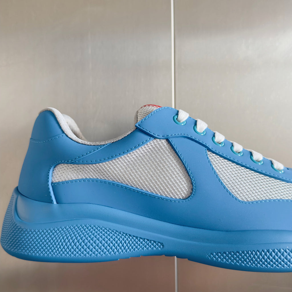 Prada unisex sneaker side view in light blue with white mesh panels