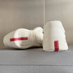 White Prada unisex sneakers with red heel tag and textured heel counter