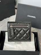 Small quilted leather flap bag, black, side with zippered pocket and CHANEL logo.