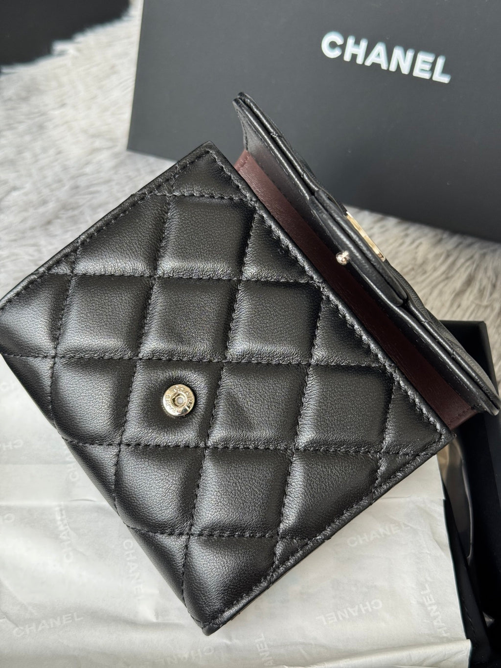 Black quilted small bag with flap, front snap button, and slim strap