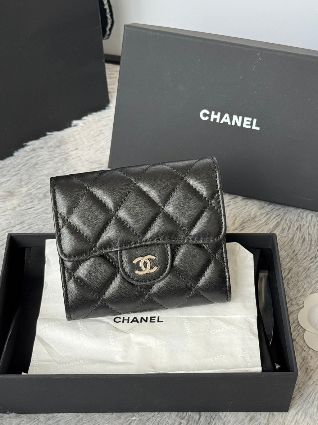 Small quilted leather flap bag, black, front view with CHANEL CC logo on clasp.