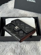 Small quilted leather flap bag, black, angled view with CHANEL CC emblem on flap.