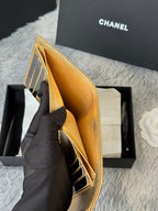 Gold small flap bag with stitched interior pocket, held by glove