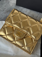 Close-up of Chanel small gold quilted mini flap bag front with CC clasp