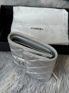 Chanel silver quilted wristlet bag detail with rolled zipper closure and ring tab.