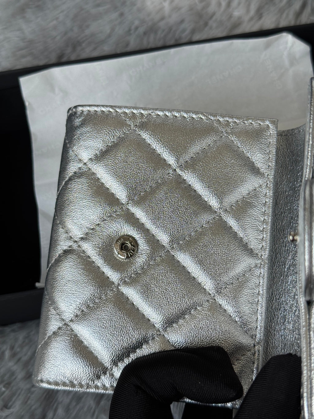 Chanel small silver quilted bag back panel with snap button CC emblem.