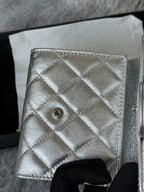 Chanel small silver quilted bag back panel with snap button CC emblem.