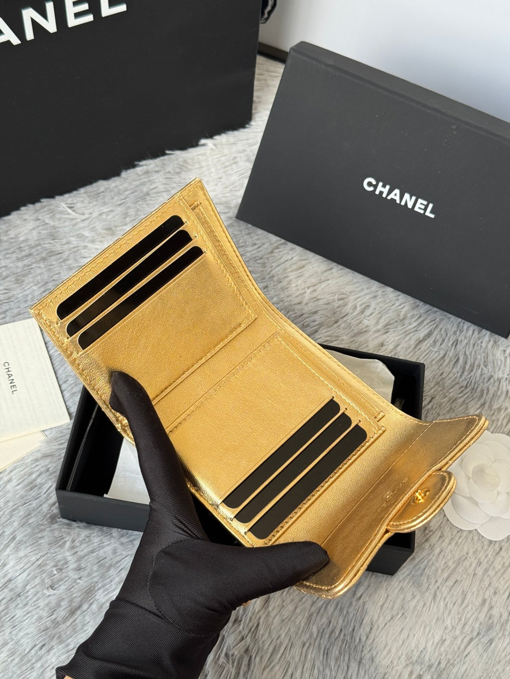 Chanel small gold quilted mini bag wallet-style with card slots, held in box