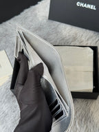Small silver bag with flap open, showing interior and side pocket