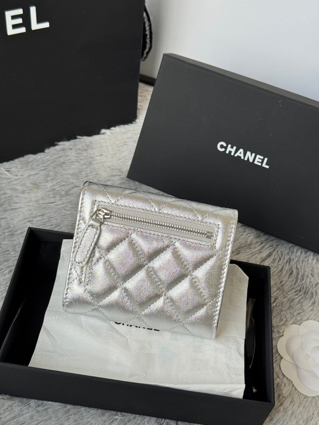 Chanel small silver quilted pouch bag with zipper and CC front emblem.