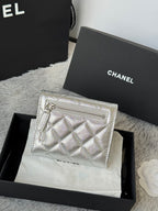 Chanel small silver quilted pouch bag with zipper and CC front emblem.