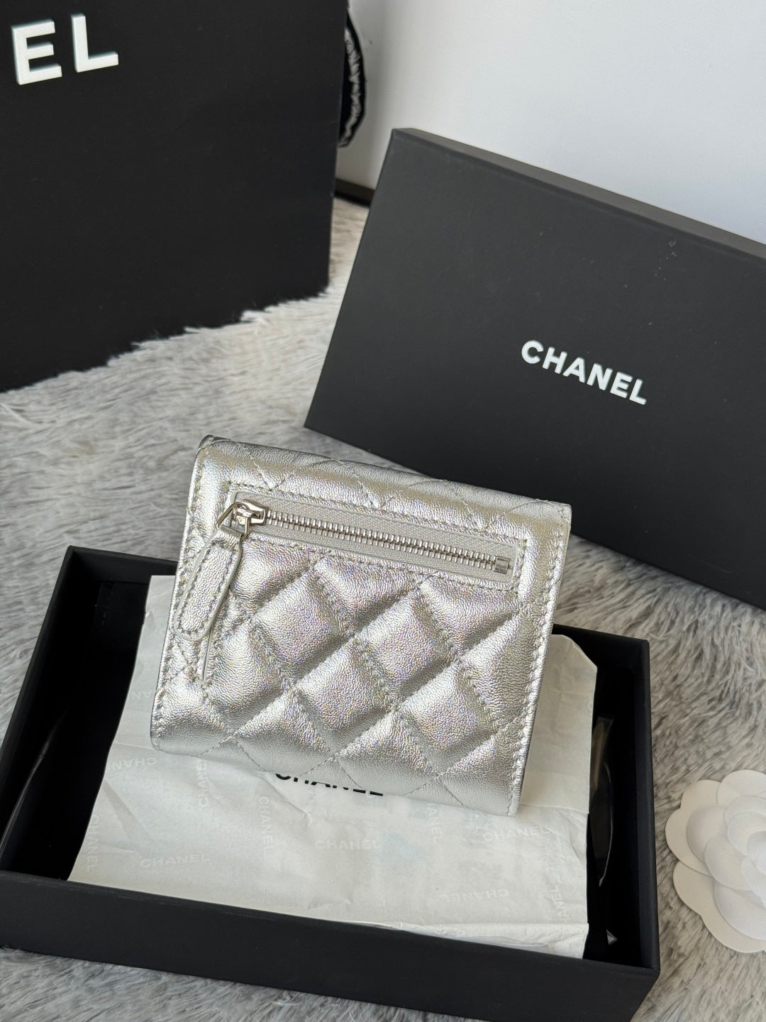 Chanel small silver quilted pouch bag with zipper and CC front emblem.
