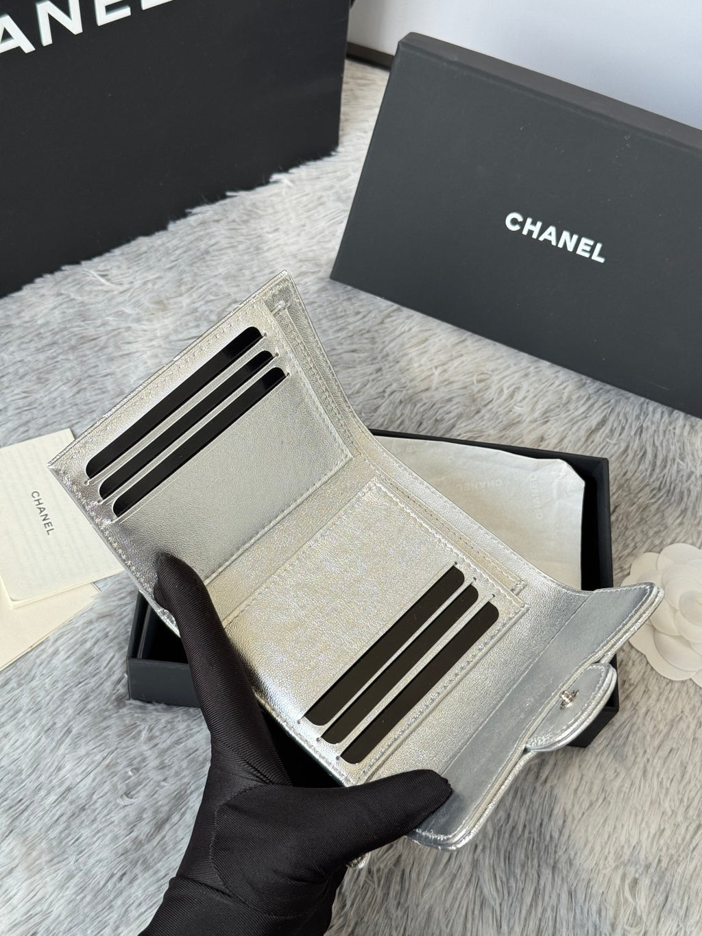 Chanel small silver bag interior with card slots and zipper pocket opening.