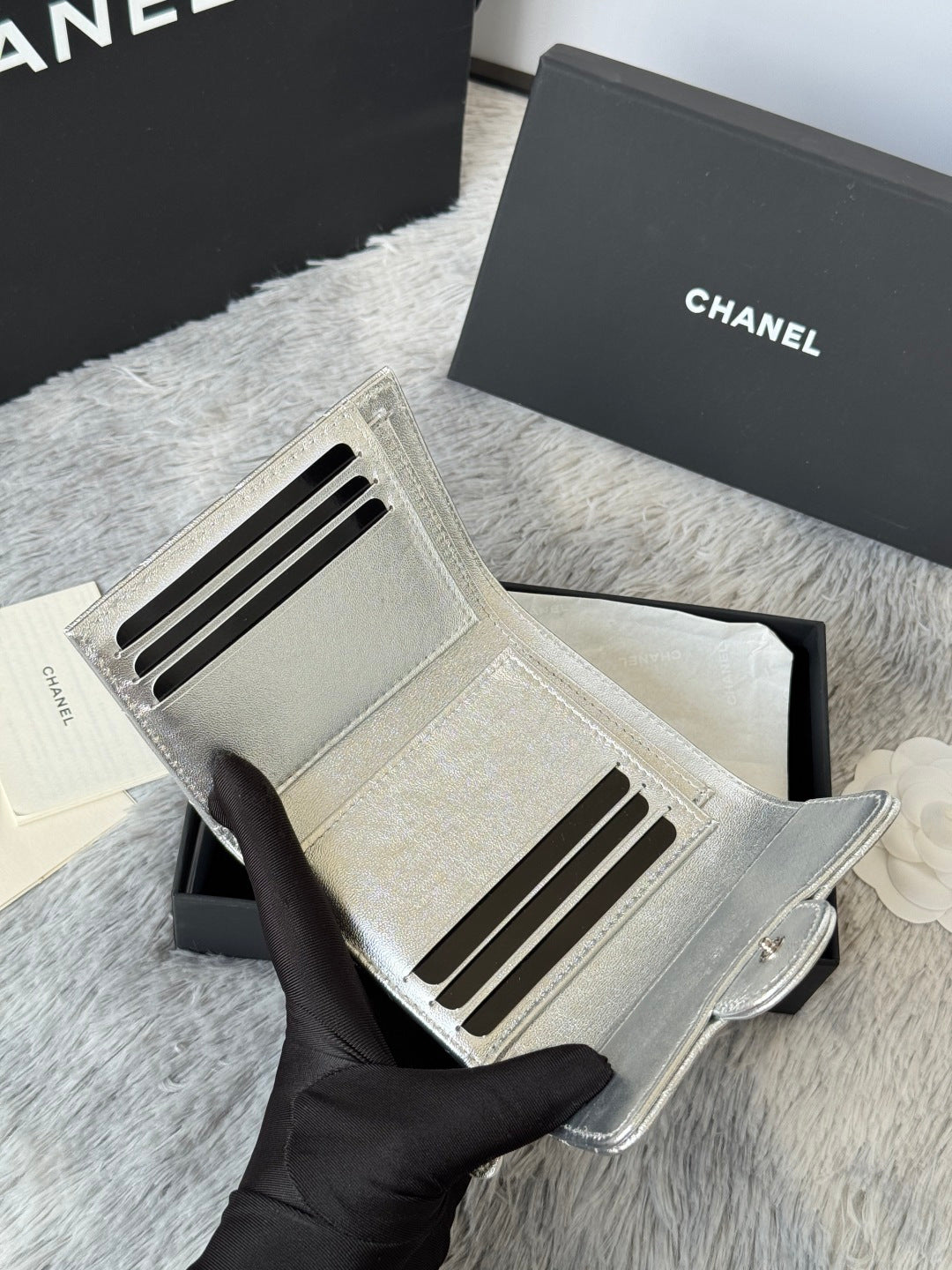 Chanel small silver bag interior with card slots and zipper pocket opening.