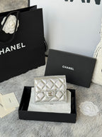 Chanel small silver quilted flap bag with chain strap, front logo medallion.