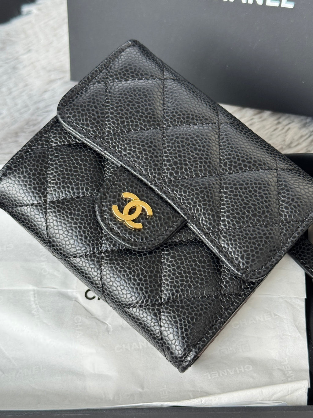 CHANEL small black embossed flap wallet with gold turn-lock logo
