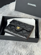 CHANEL small black textured flap wallet with round gold logo