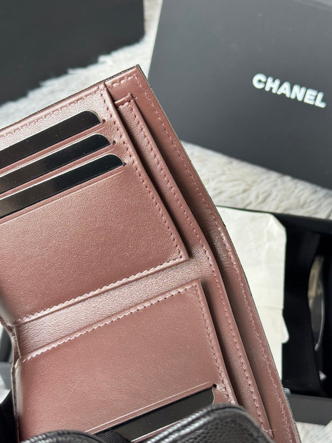 Small leather card wallet with multiple inner slots and stitched edges, pinkish-brown.