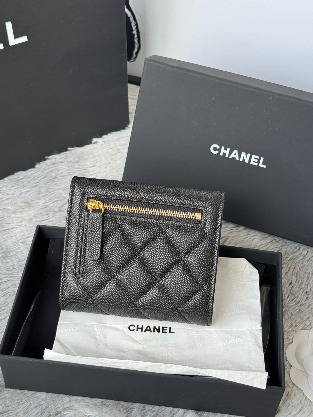 Small bag with quilted dark leather, top zip opening, and gold-tone CHANEL hardware.