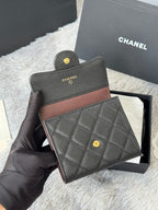 Small bag set: dark quilted leather with brown trim, snap button, and small gold CHANEL logos.
