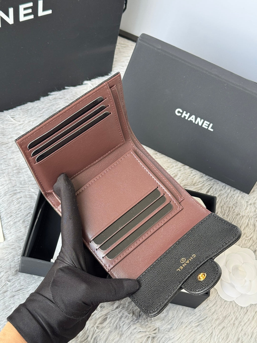 Small bag wallet open view with card slots in dark and brown panels; gold CHANEL button.