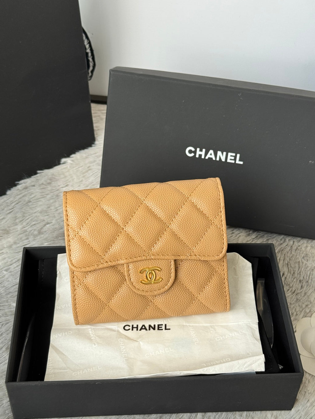 Small quilted flap bag, light tan leather with Chanel logo and snap clasp