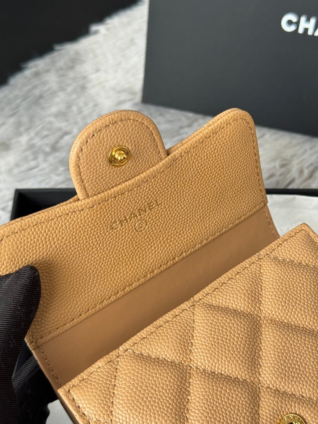 Small quilted flap bag close-up, tan leather with card-slot lining and Chanel