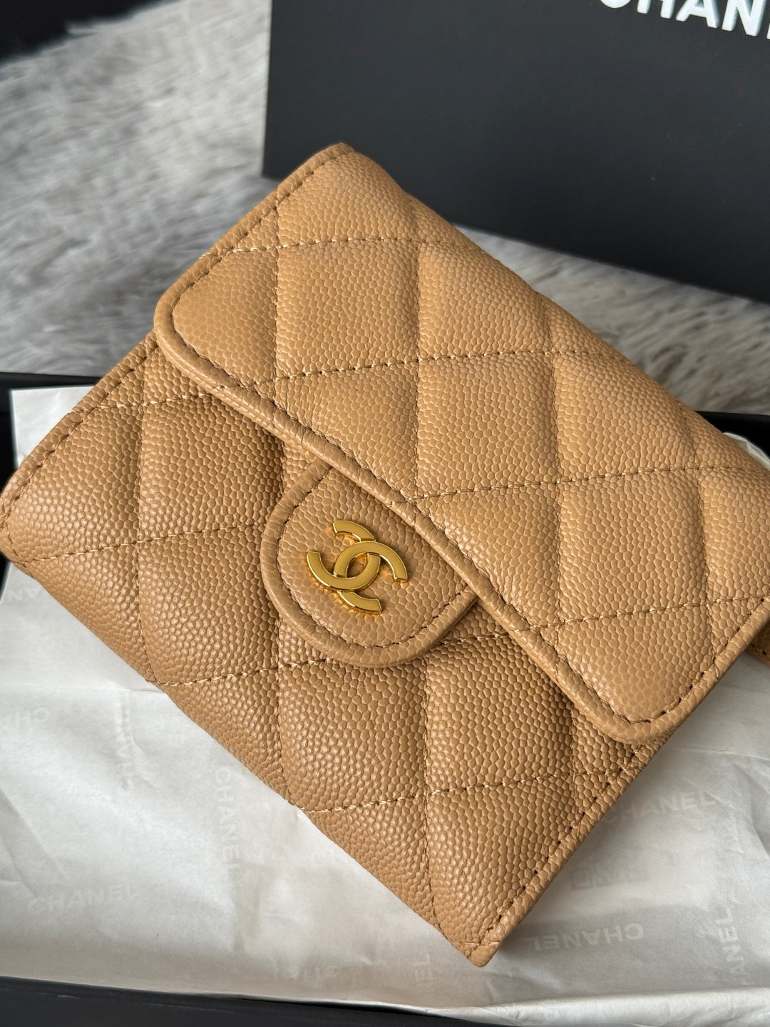Small quilted flap bag close-up, tan leather with gold Chanel CC emblem