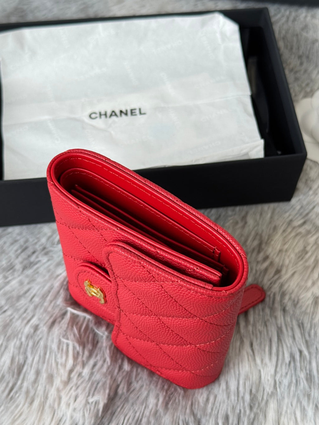 Red small bag open interior with quilted texture and gold logo on front panel