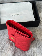 Red small bag open interior with quilted texture and gold logo on front panel