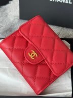 Red quilted small bag close-up with gold double-C emblem and zip pocket