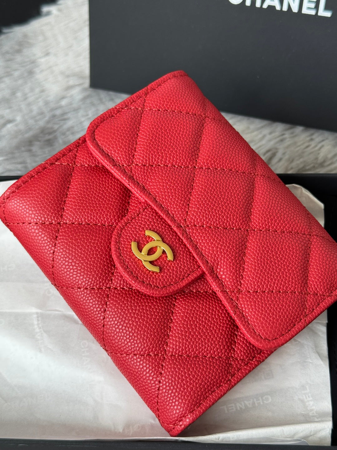 Red quilted small bag close-up with gold double-C emblem and zip pocket