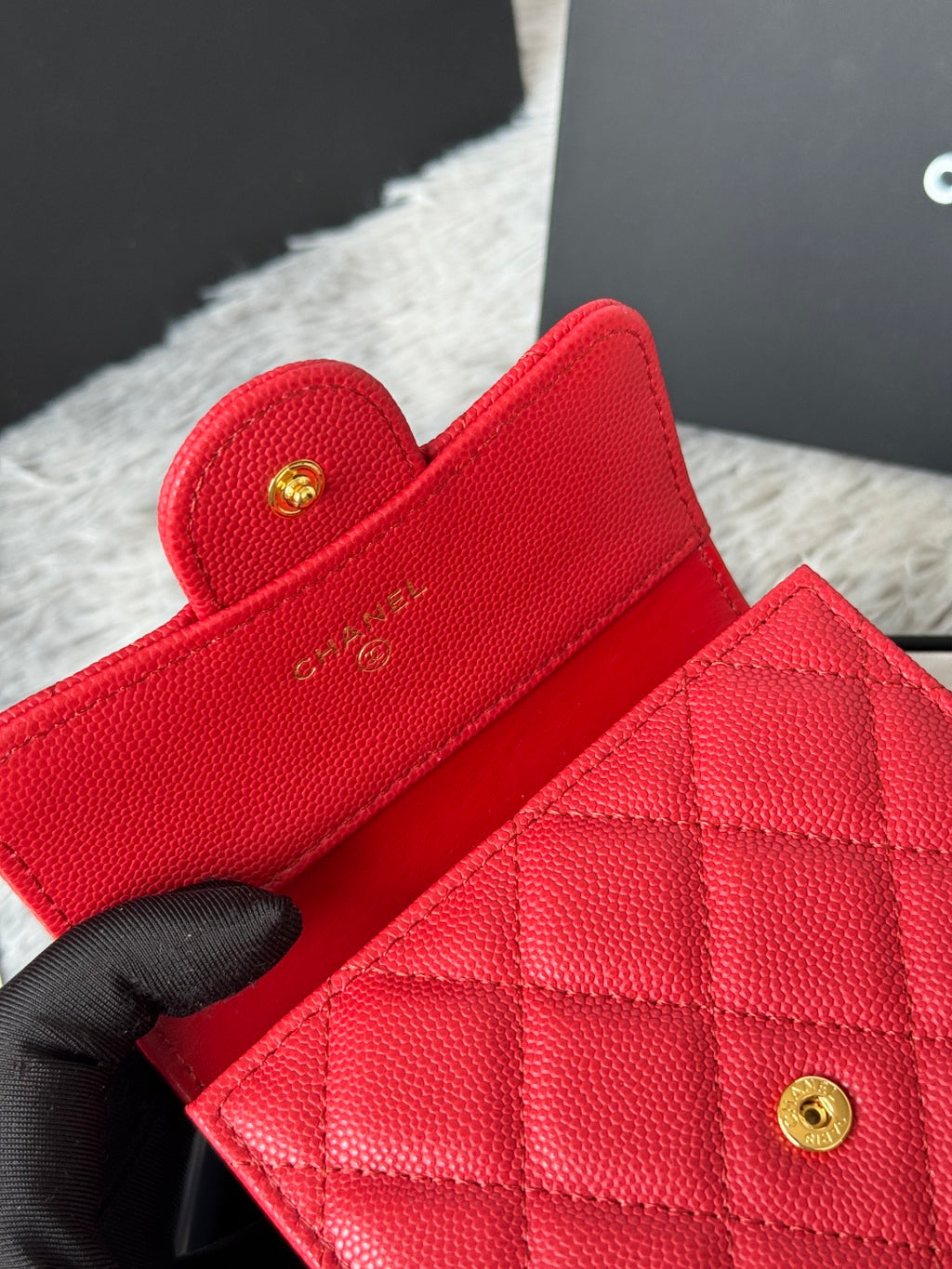 Red quilted card wallet interior with gold-tone snap and stitched panel details