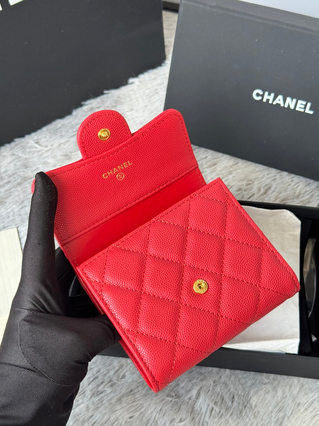Red quilted card wallet with fold-over flap and two gold-tone snap buttons