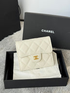 Off-white quilted flap bag with gold Chanel logo clasp, angled front view.