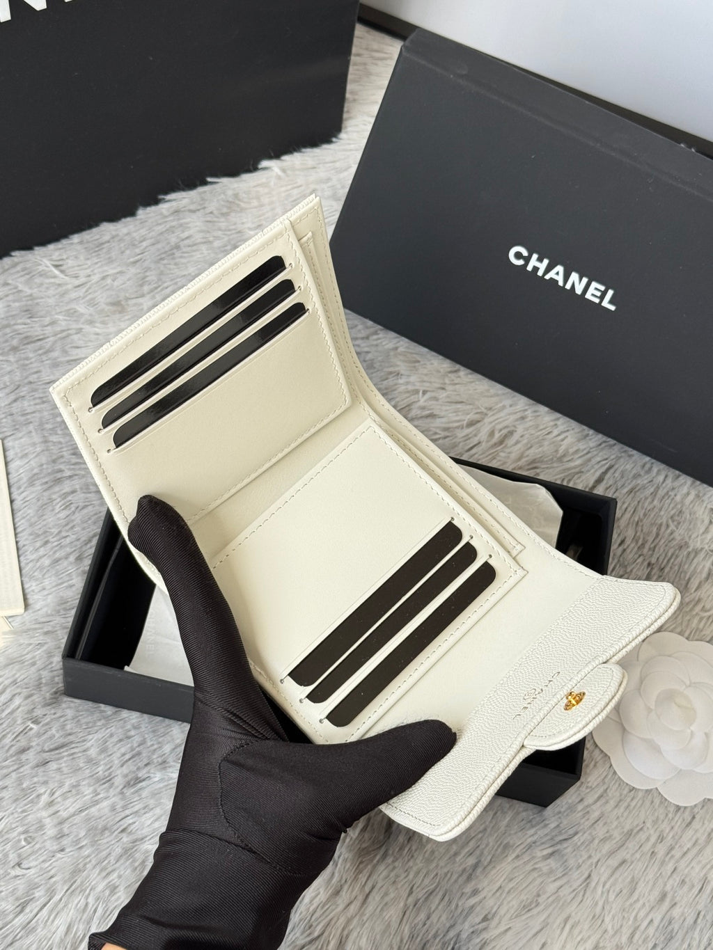 Off-white card holder bag with gold Chanel logo on front flap, interior view.