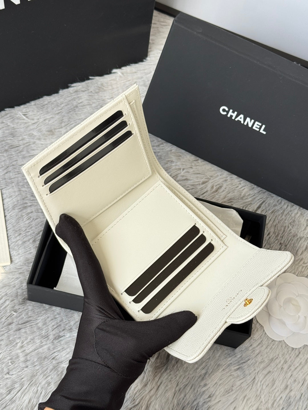 Off-white card holder bag with gold Chanel logo on front flap, interior view.