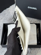 Off-white small bag with hinged top flap, held open showing interior