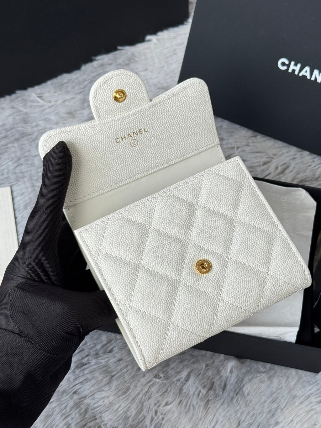 Off-white textured mini wallet bag with gold Chanel button, front angled view.