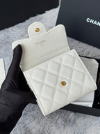Off-white textured mini wallet bag with gold Chanel button, front angled view.
