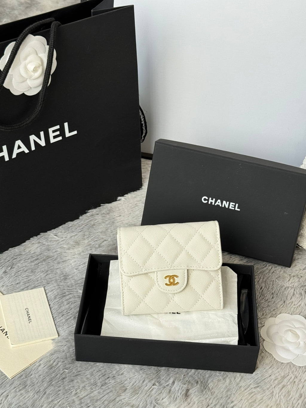 Off-white quilted flap bag with gold Chanel logo and chain strap, front view.