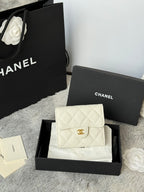 Off-white quilted flap bag with gold Chanel logo and chain strap, front view.