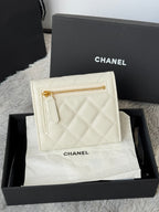 Off-white quilted mini bag with gold zipper and Chanel branding, front view.