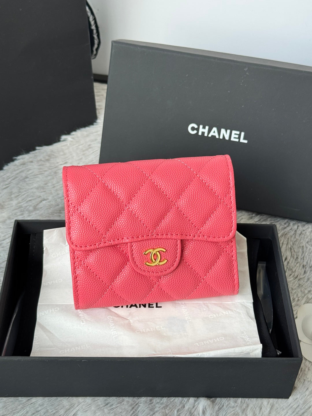 Pink quilted flap bag with gold CC logo and snap flap, in black gift box
