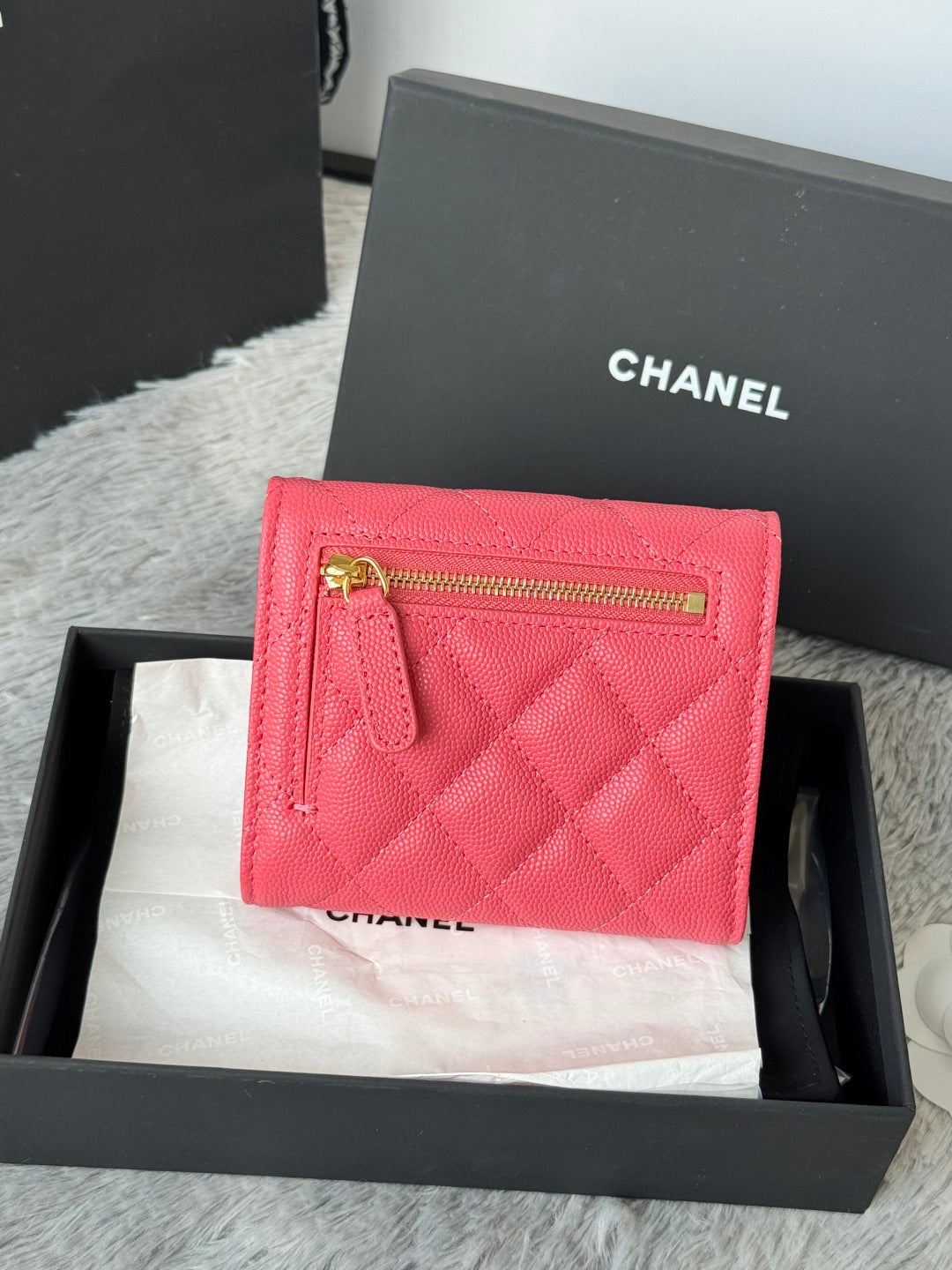 Pink quilted card case with gold top zipper and CC emblem, in gift box