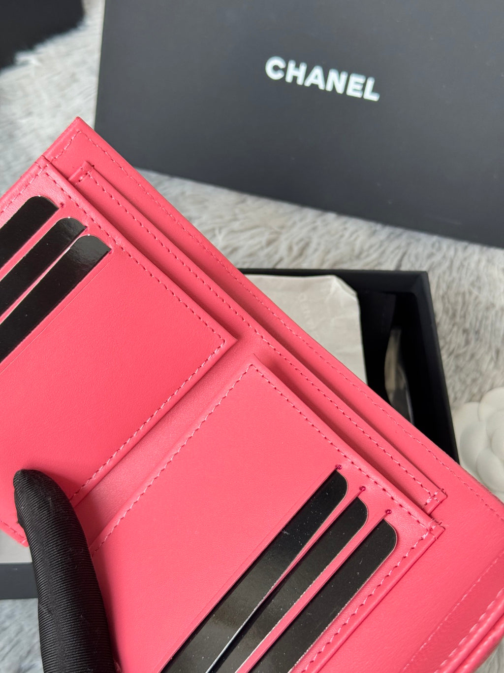 Small pink Chanel bag with black-striped card slots and stitched front