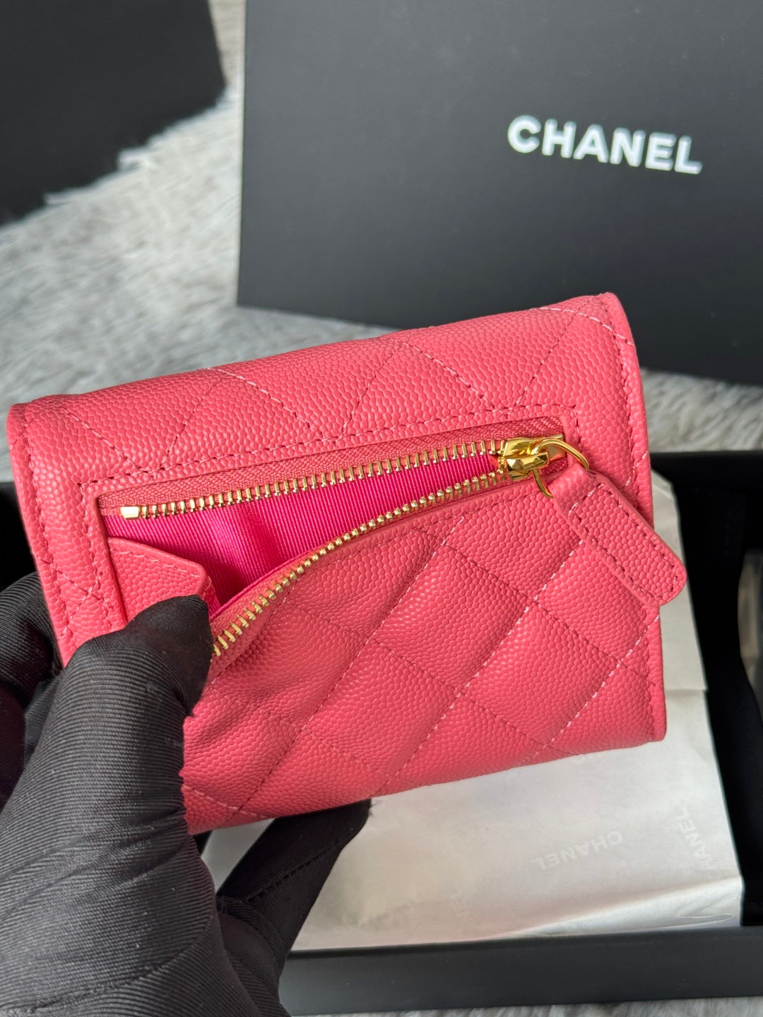 Pink quilted flap bag with gold zipper and CC emblem, partially open view