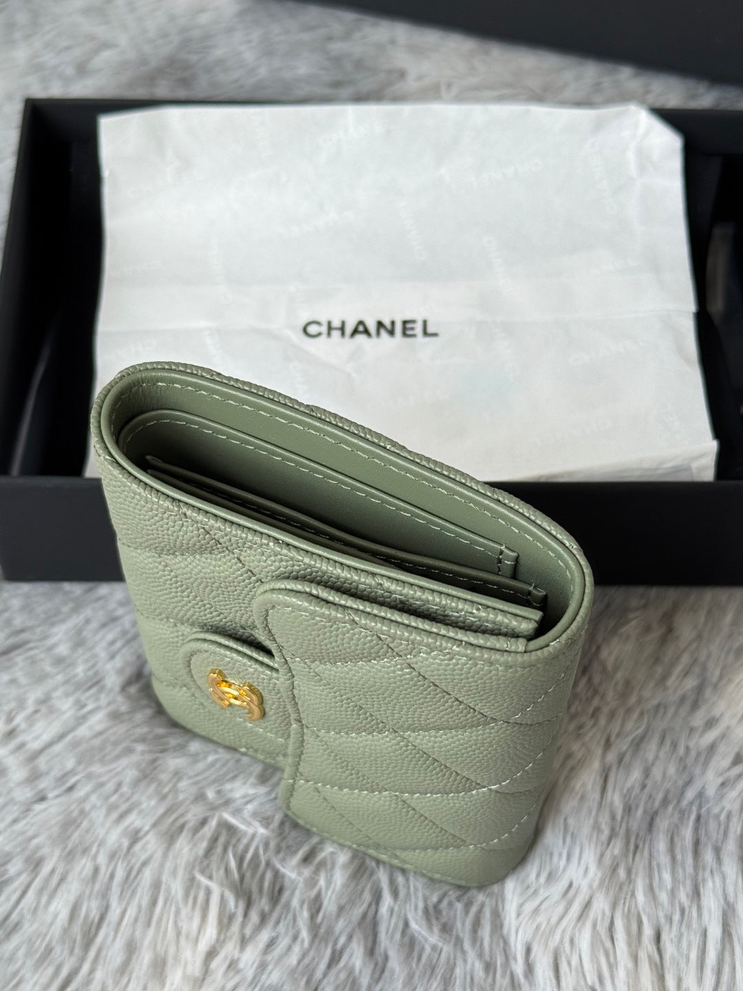 Small light green leather crossbody-style bag with gold-tone CHANEL charm