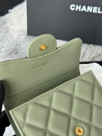 Small light green quilted flap bag with gold button and CHANEL logo