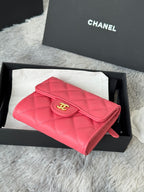 Pink quilted flap bag with gold CC emblem and short wrist strap, gift box view